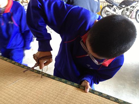 畳に針を刺す中学生