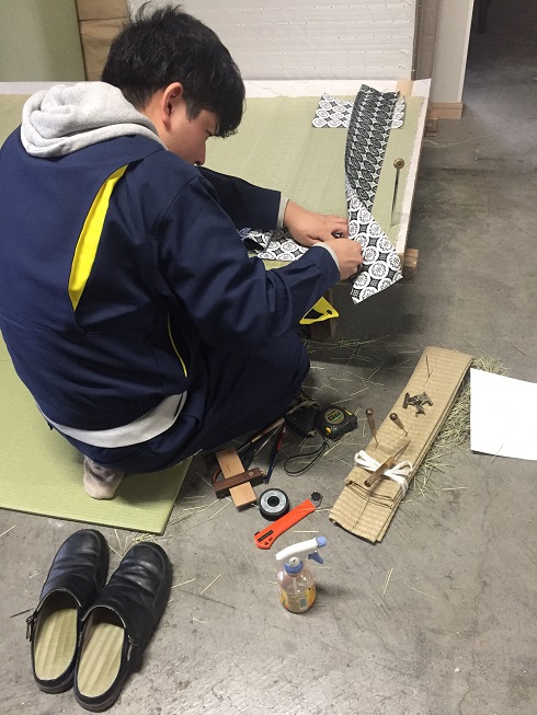 拝敷を縫う長男の後ろ姿